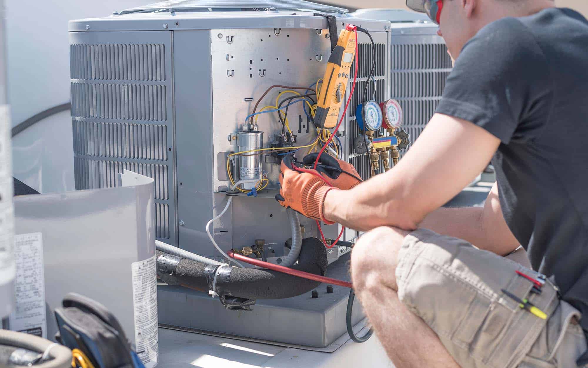 HVAC Technician Working On Controls Of Air Conditioner 