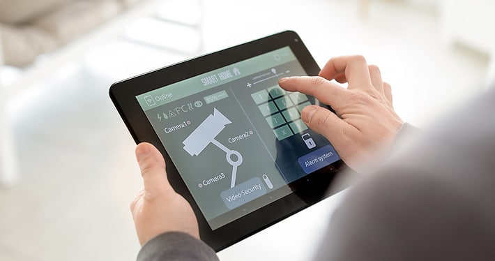 Side view of a person on a tablet with a security camera footage interface