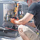 Side view of technician working on controls of air conditioner