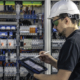 Man, an electrical working in a building automation system, uses a tablet.